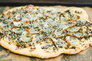 Vegan Potato and Pesto Pizza Topped with Crème Fraîche and Micro Greens
