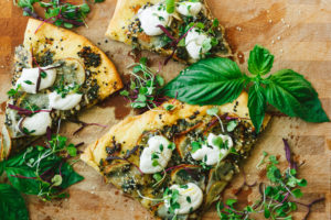 Vegan Potato and Pesto Pizza Topped with Crème Fraîche and Micro Greens