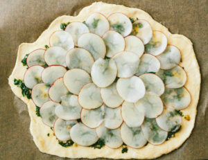 Vegan Potato and Pesto Pizza Topped with Crème Fraîche and Micro Greens