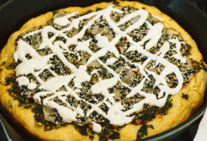 Crispy Seasoned Potato Pesto Pizza with Cashew Mozzarella Cream and Arugula on an Herbed Crust