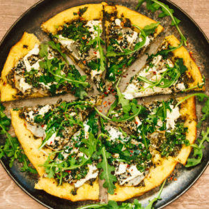 Crispy Seasoned Potato Pesto Pizza with Cashew Mozzarella Cream and Arugula on an Herbed Crust